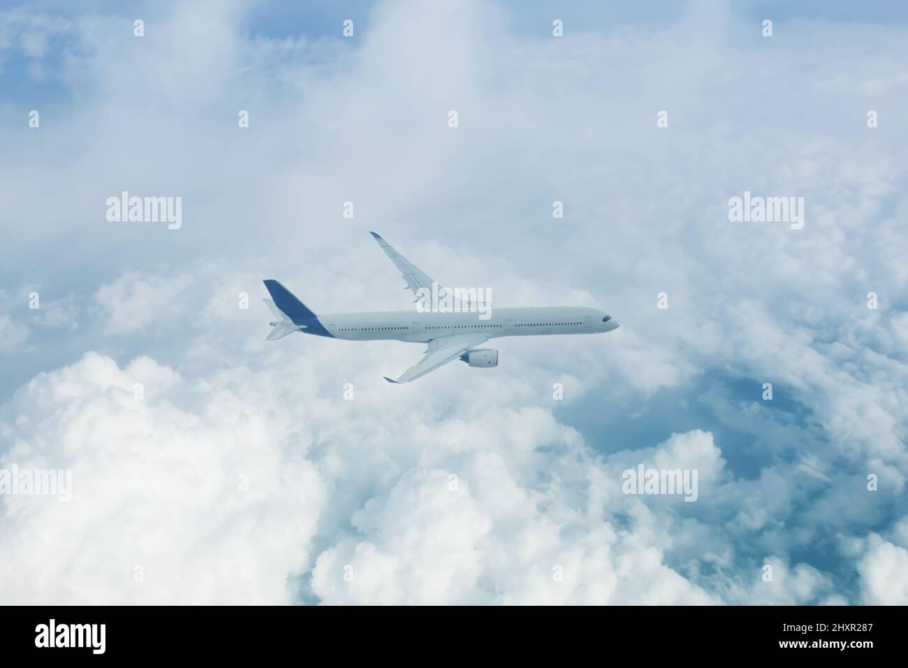 Passenger plane flies high above the clouds aerial view Stock Photo