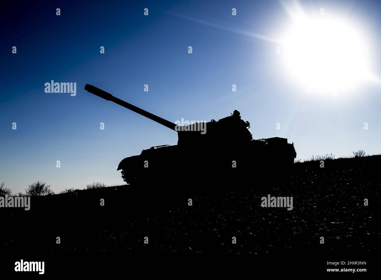 Silhouette of a main battle tank on a battlefield Stock Photo