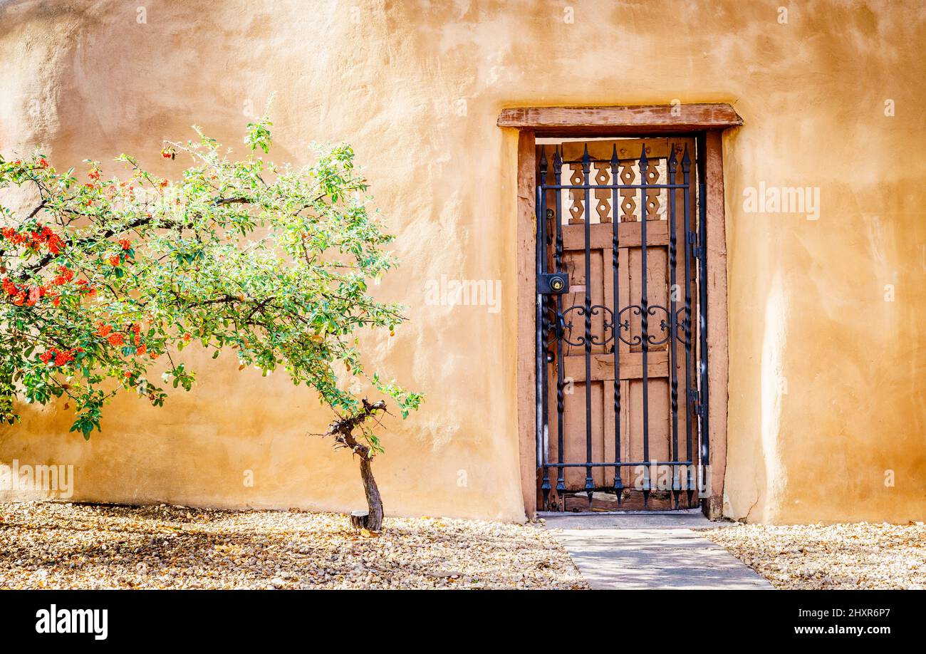Beautiful firethorn tree in front of traditional adobe building in Santa Fe, New Mexico Stock Photo