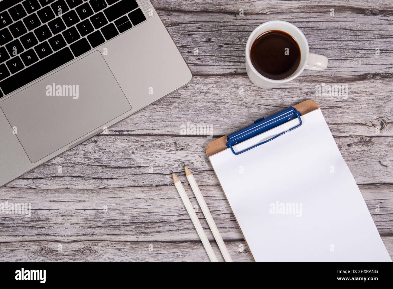 Office desk with smartphone, laptop and cup of coffee. Top view with copy space. Stock Photo
