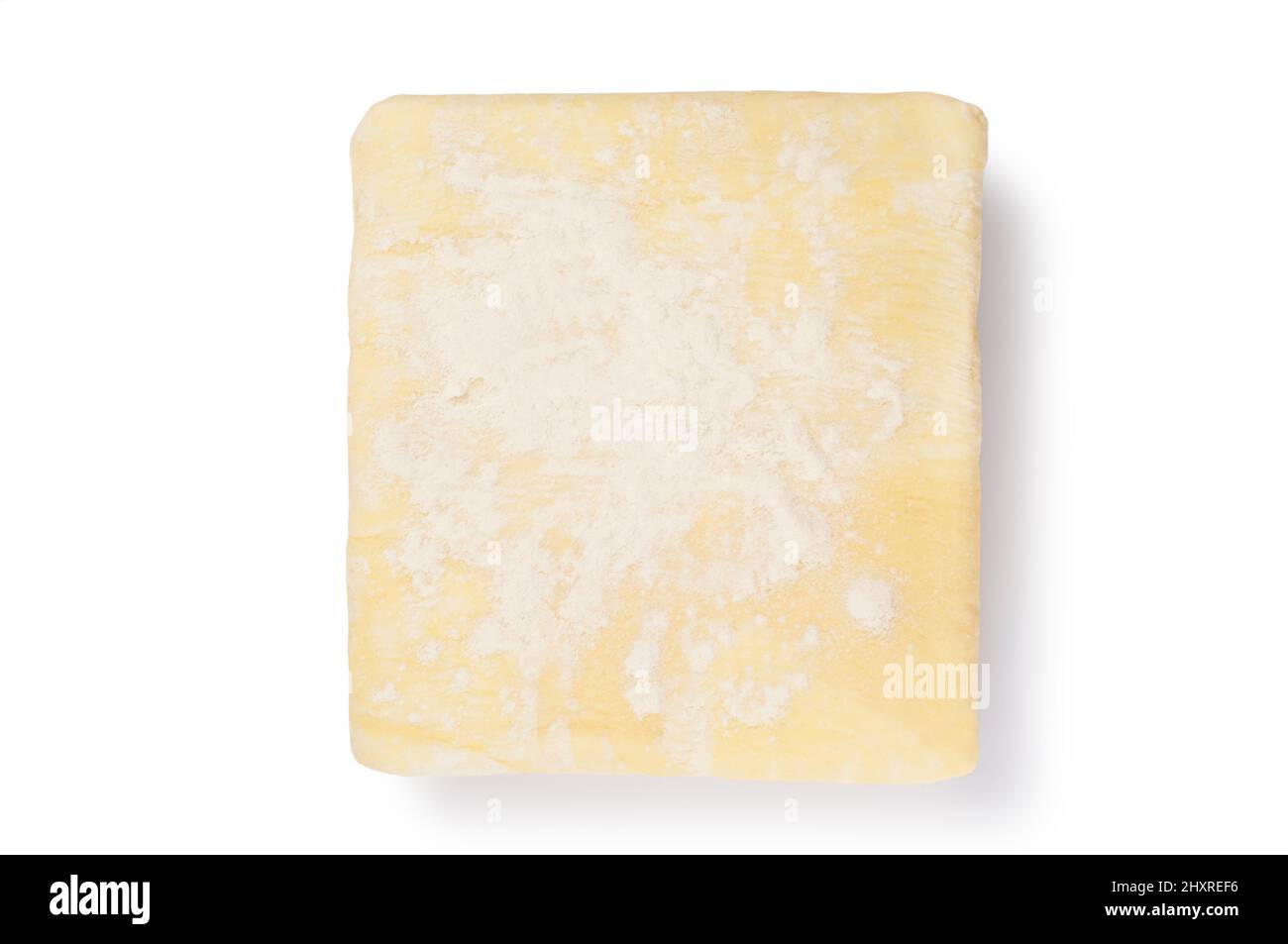 Studio shot of a block of uncooked puff pastry cut out against a white background - John Gollop Stock Photo