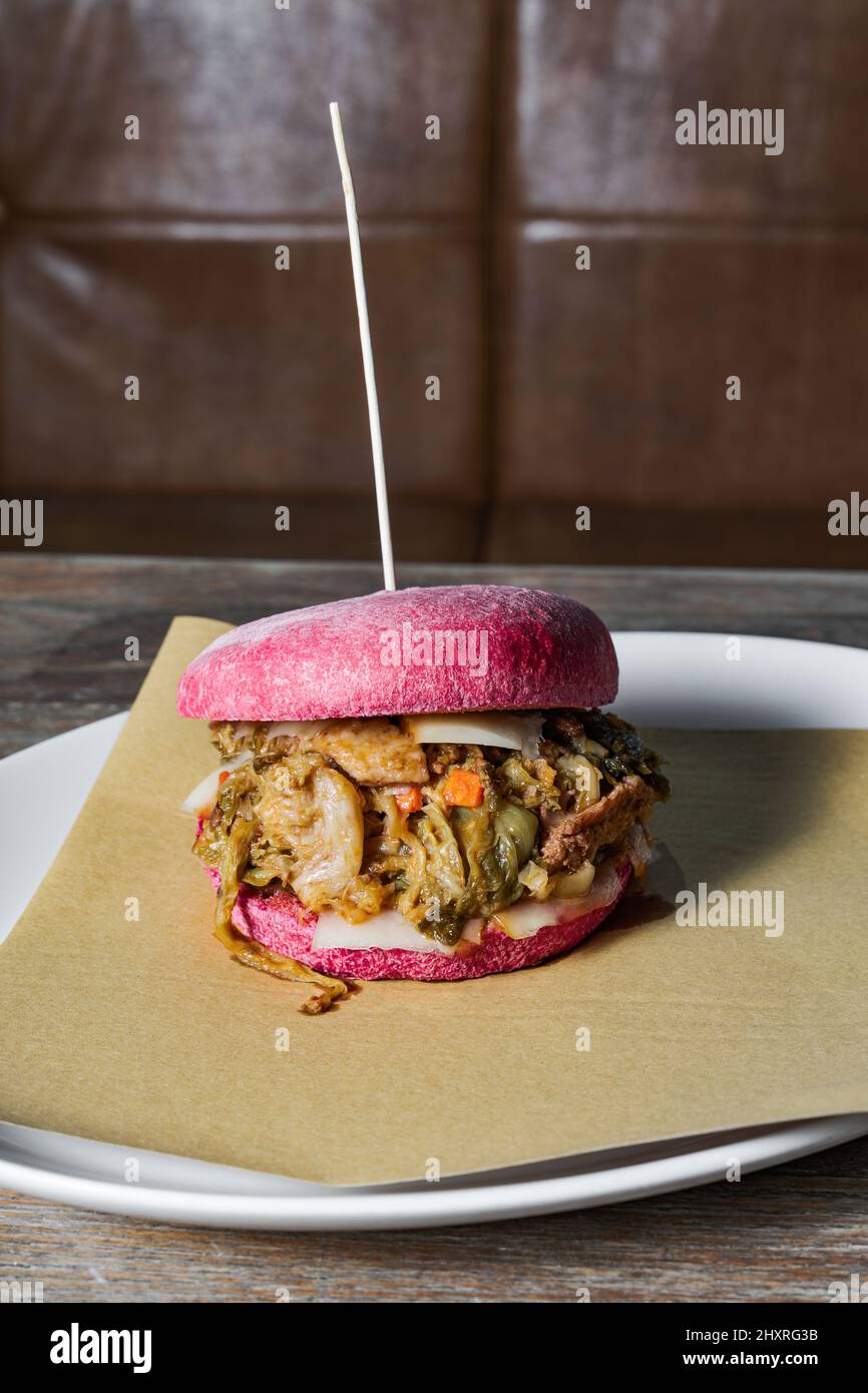 pink burger with Italian cassuola on a table in a restaurant. a traditional dish in a modern way Stock Photo