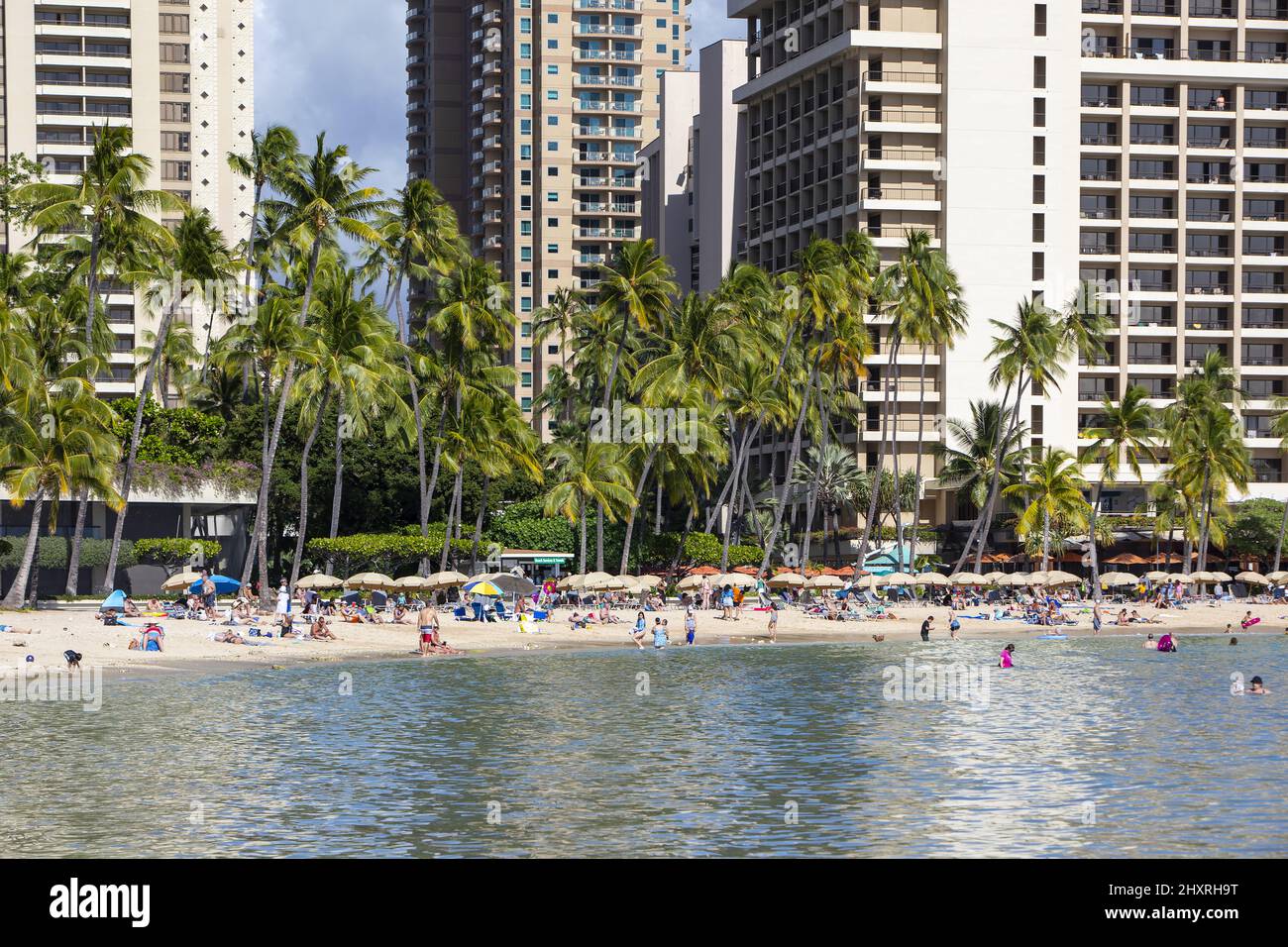 Distant view of the Hilton Hawaiian Village Waikiki Beach Resort and beach with people in