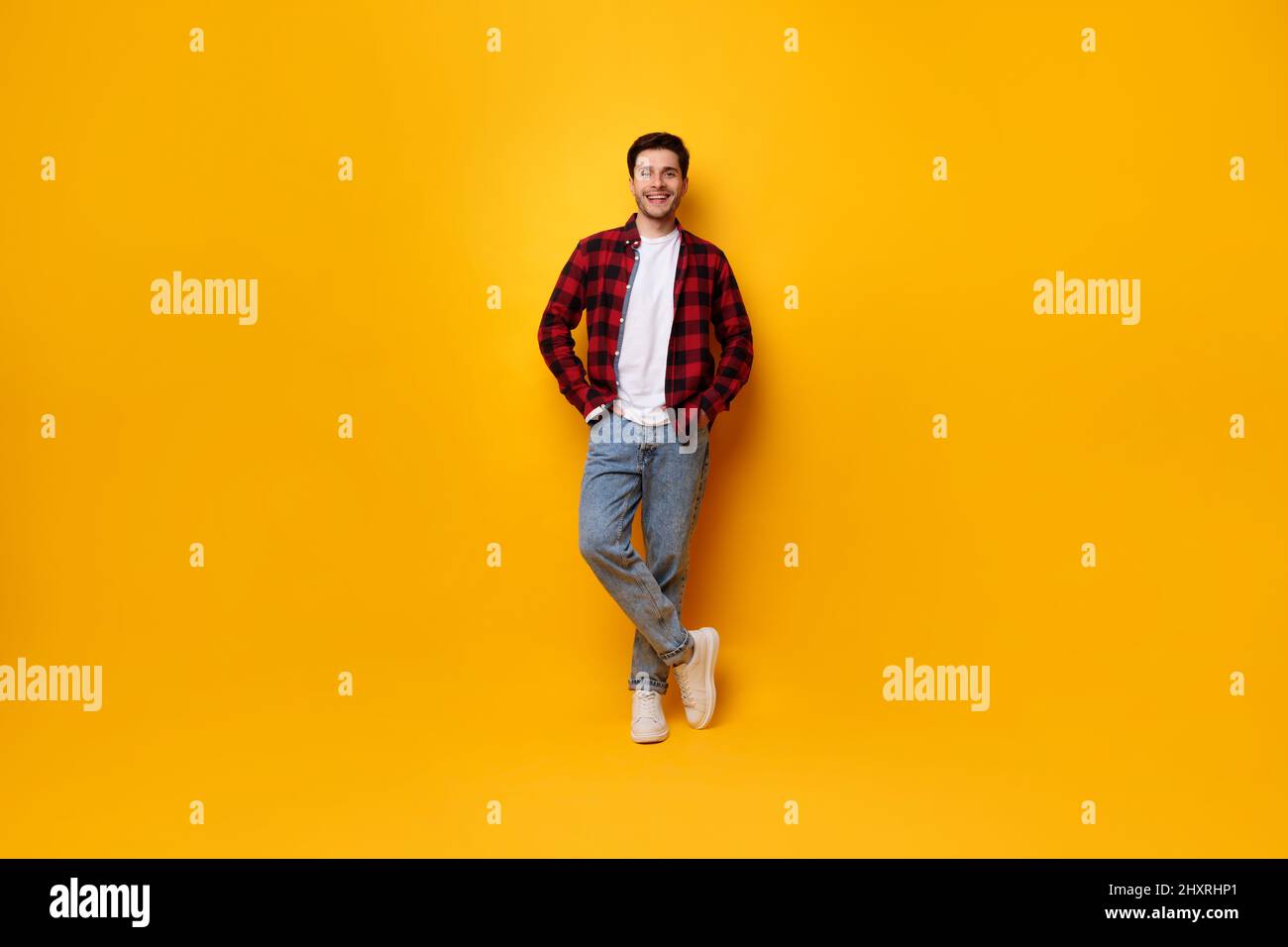Portrait of happy young man posing at yellow studio Stock Photo