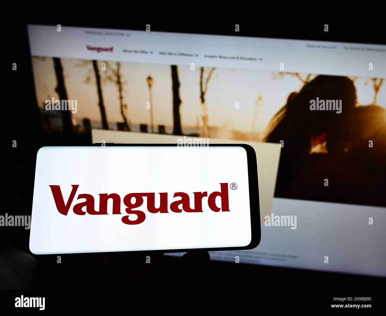 Person holding cellphone with logo of US financial company The Vanguard Group Inc. on screen in front of business web page. Focus on phone display. Stock Photo