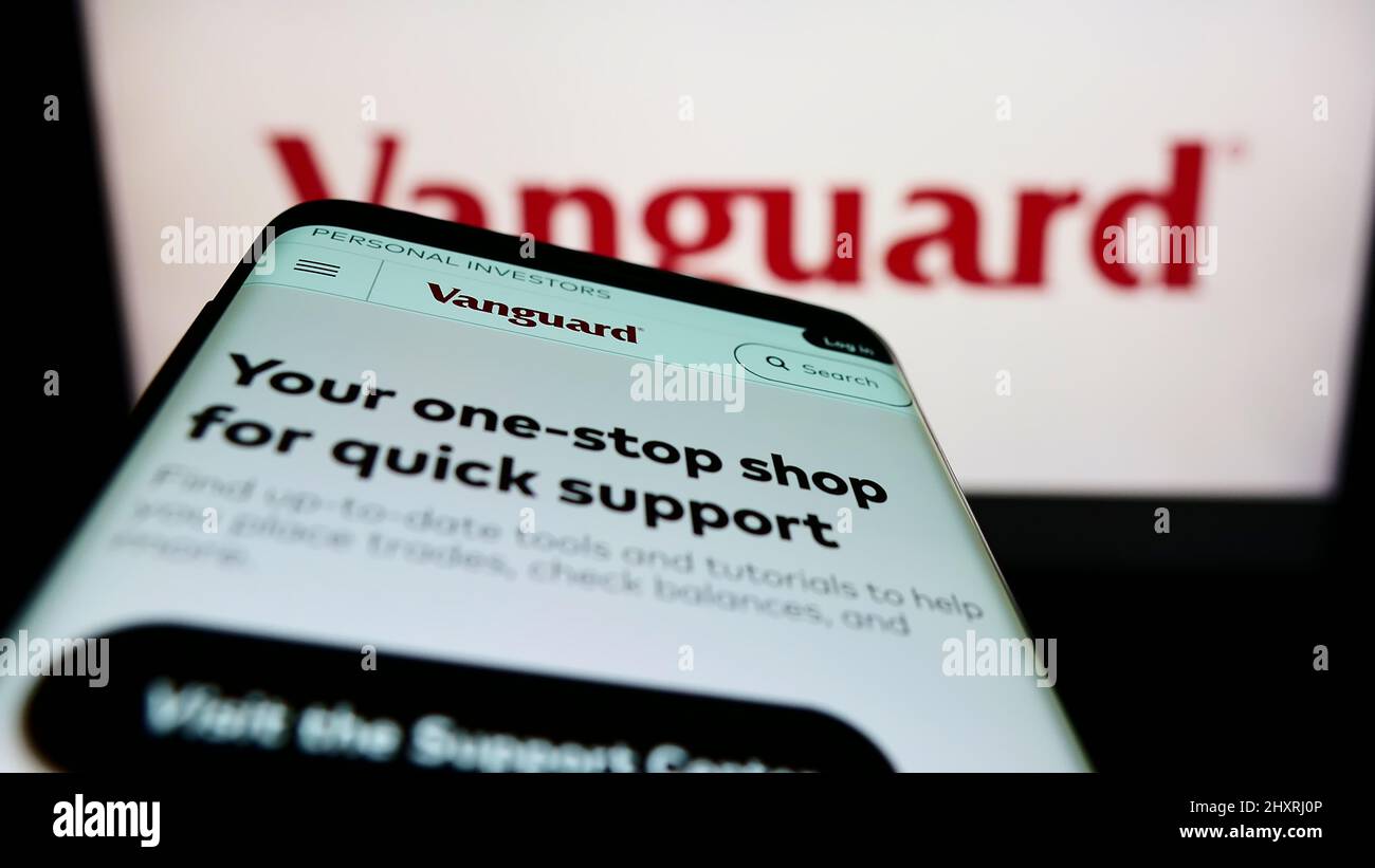 Mobile phone with website of American financial company The Vanguard Group Inc. on screen in front of logo. Focus on top-left of phone display. Stock Photo