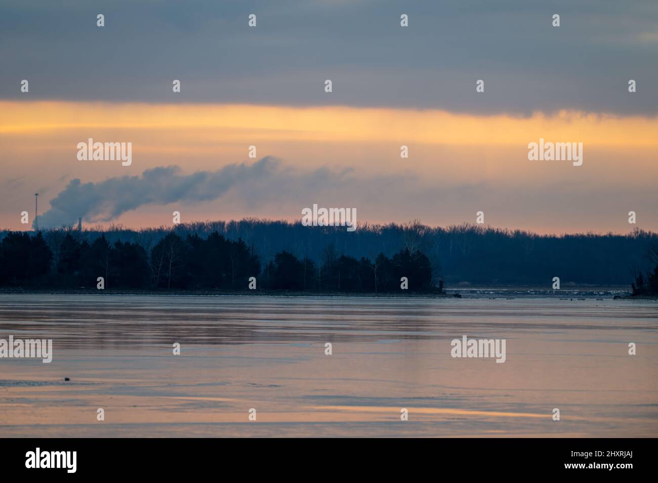 Lake near the forest at cloudy orange sunset Stock Photo - Alamy
