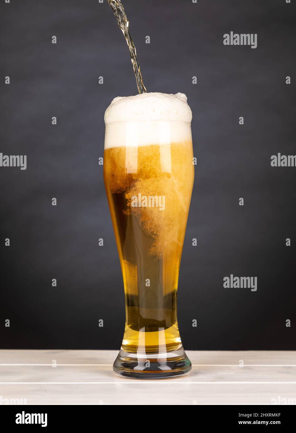 Pour beer in a glass with black background Stock Photo Alamy