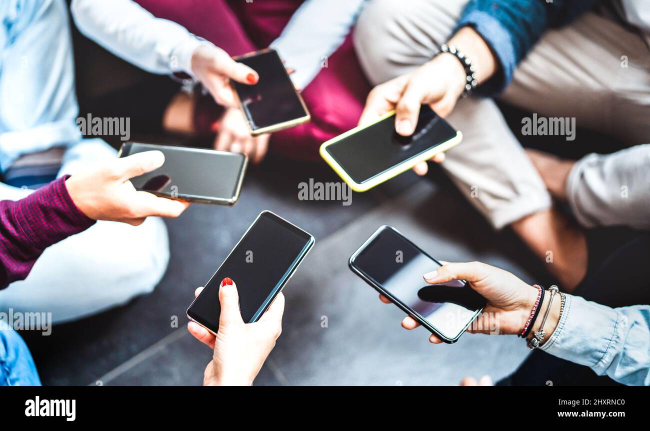 Angle closeup of hands using mobile smart phone - Detail of gen z friends sharing photo on social media network with modern smartphone - Tech life lif Stock Photo