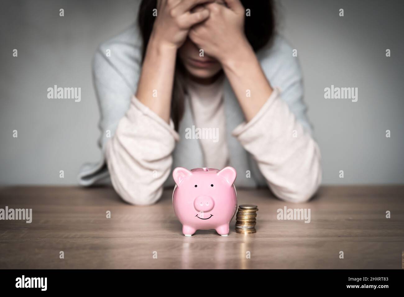 Sad girl with a piggy bank at home Stock Photo - Alamy