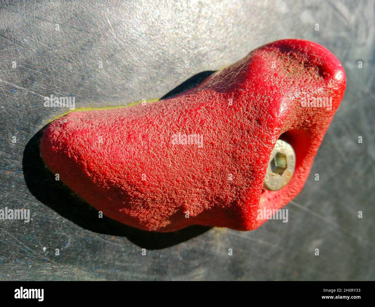Close up of a red climbing hold on a climbing facility for children on a playground Stock Photo