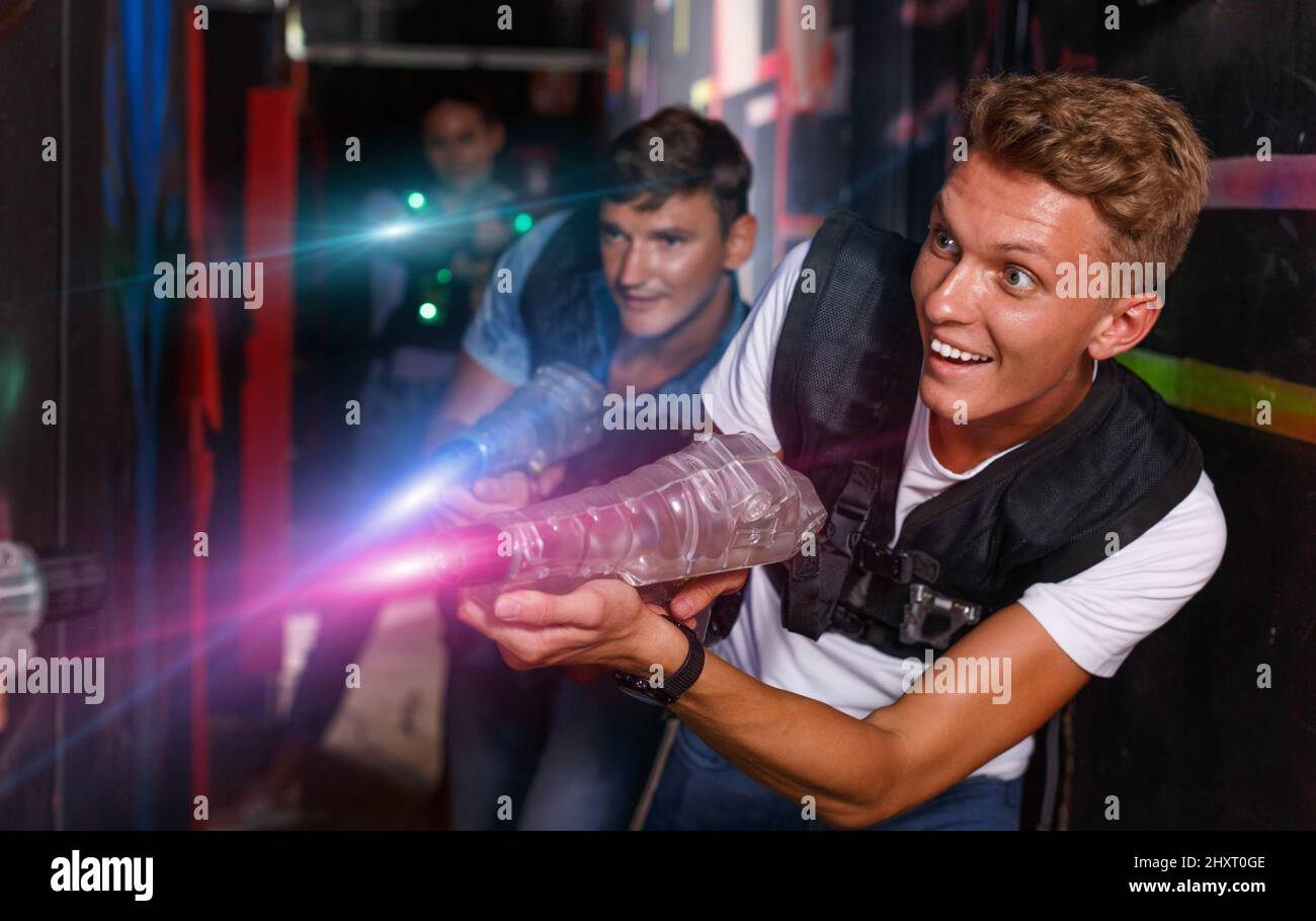 Young guy holding colored laser guns and took aim during laser t Stock  Photo - Alamy