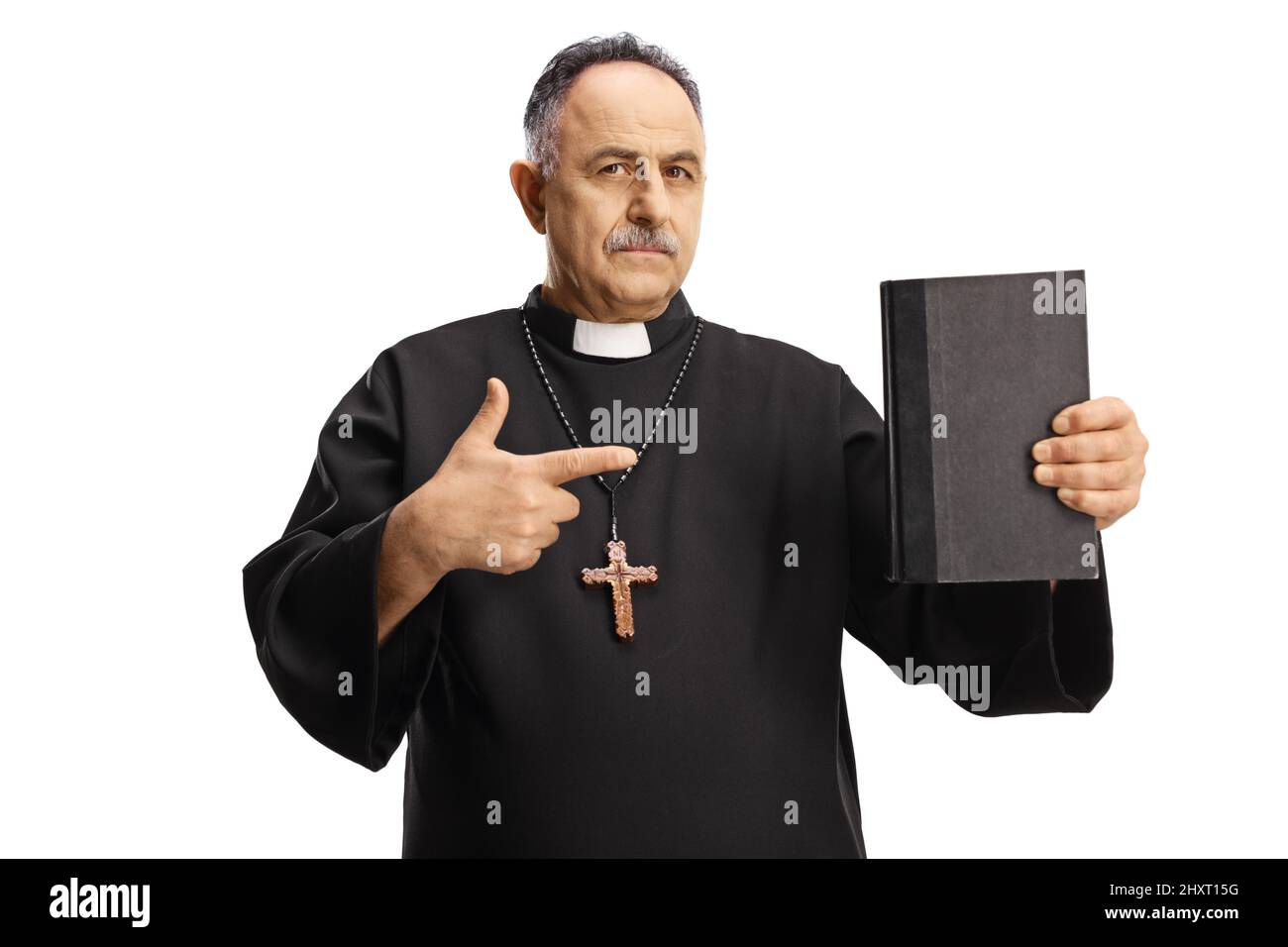 Mature priest holding a bible and pointing isolated on white background Stock Photo