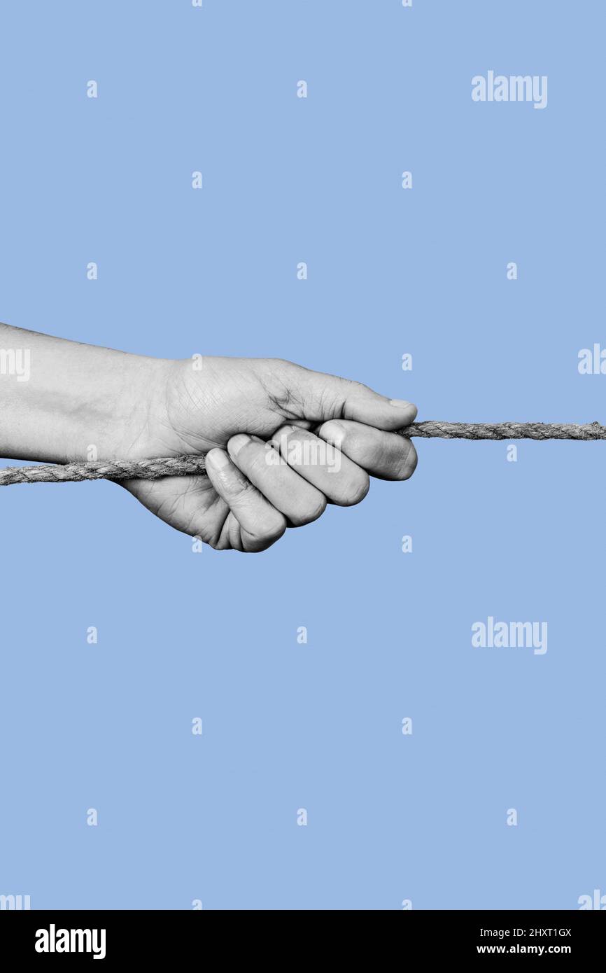 a young man pulls a rope in black and white, on a blue background Stock ...