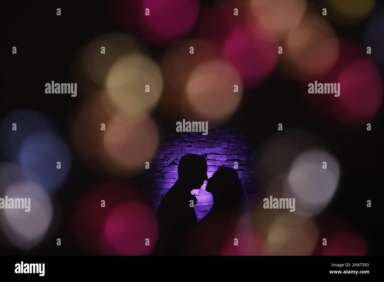 Silhouette of a couple kissing on a bokeh background Stock Photo - Alamy