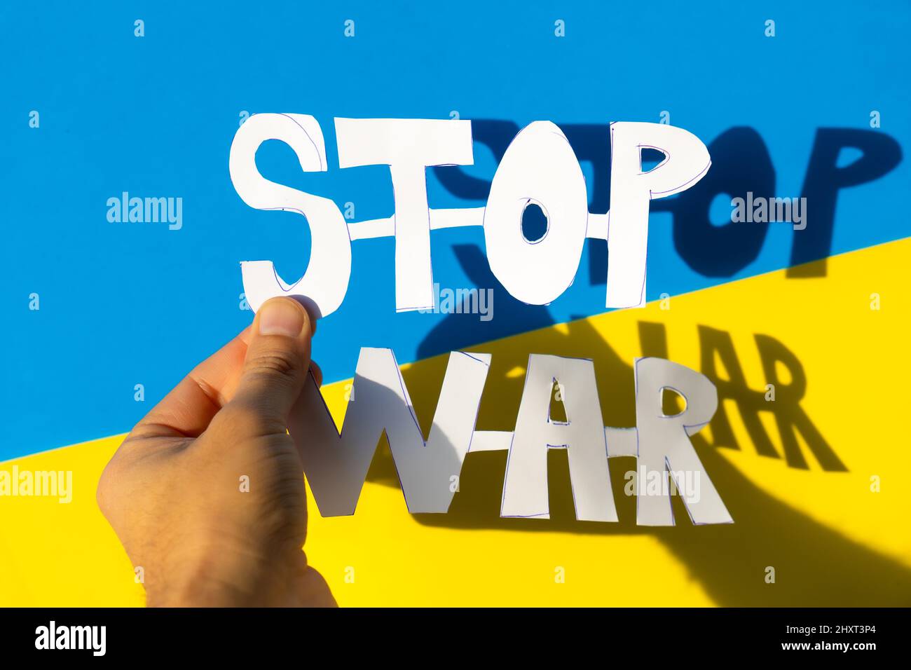 Woman's hand holding a stop war text with the conflict between Ukraine and Russia Stock Photo