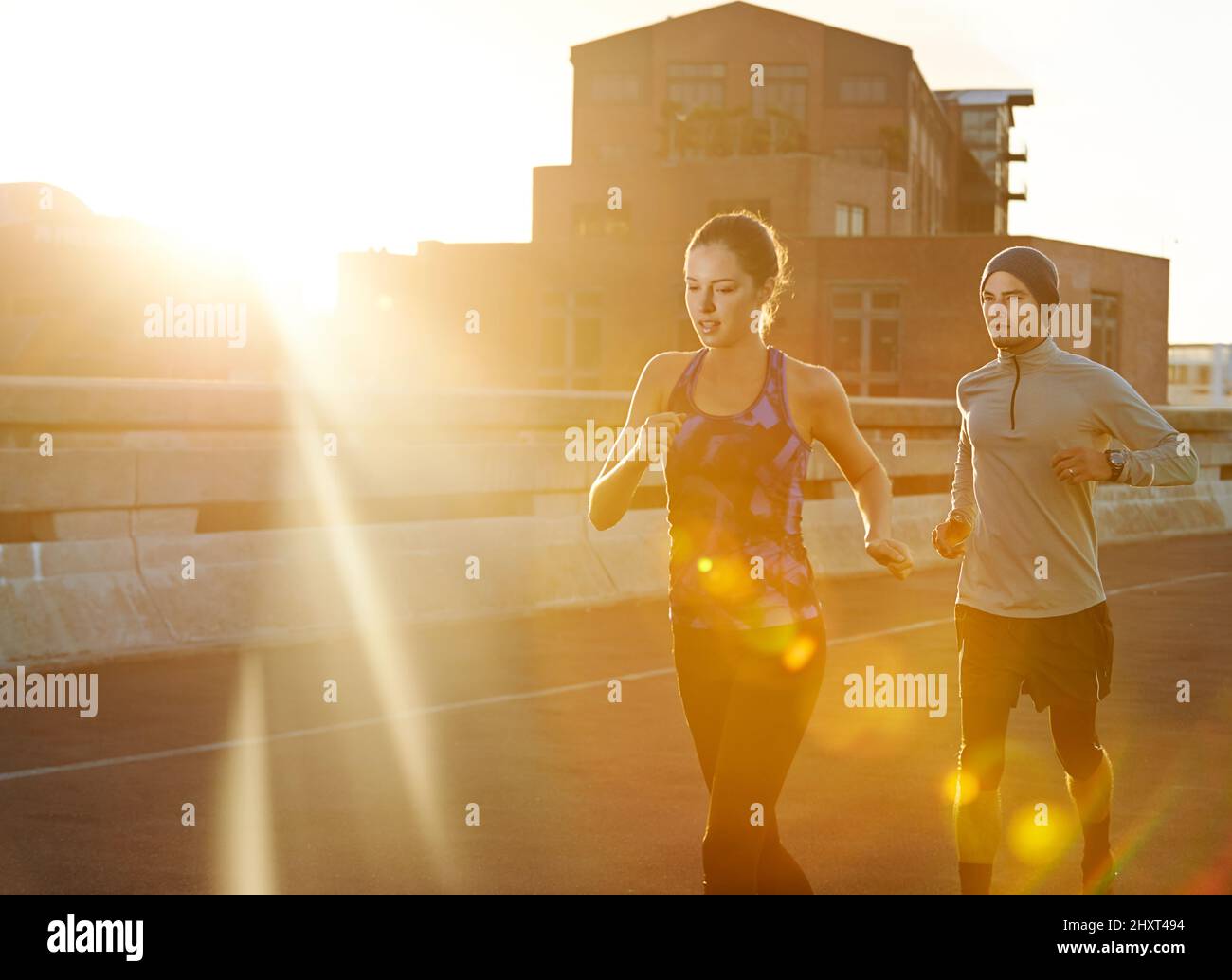 Taking the lead. Shot of two friends out jogging in the city in the early morning. Stock Photo