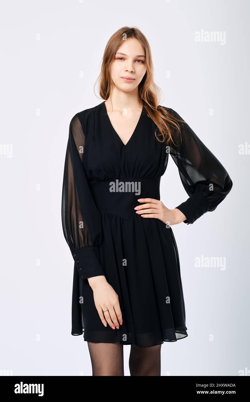 Young woman posing in studio in little black dress with one arm on waist Stock Photo Alamy