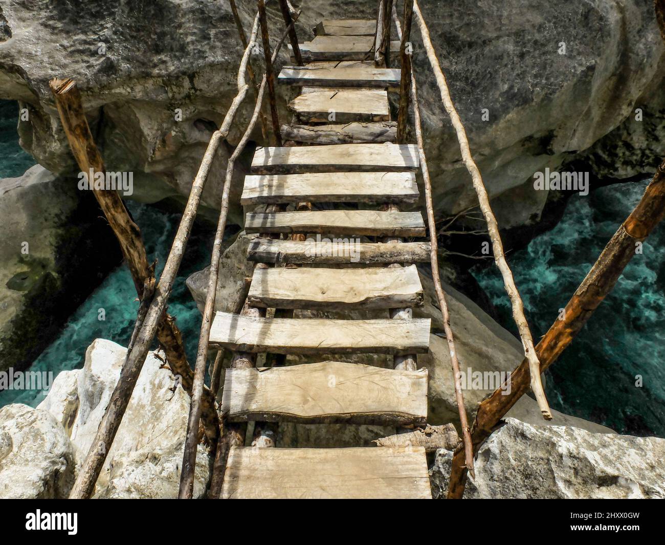 Beautiful shot of an old wooden bridge connecting two big rocks over ...