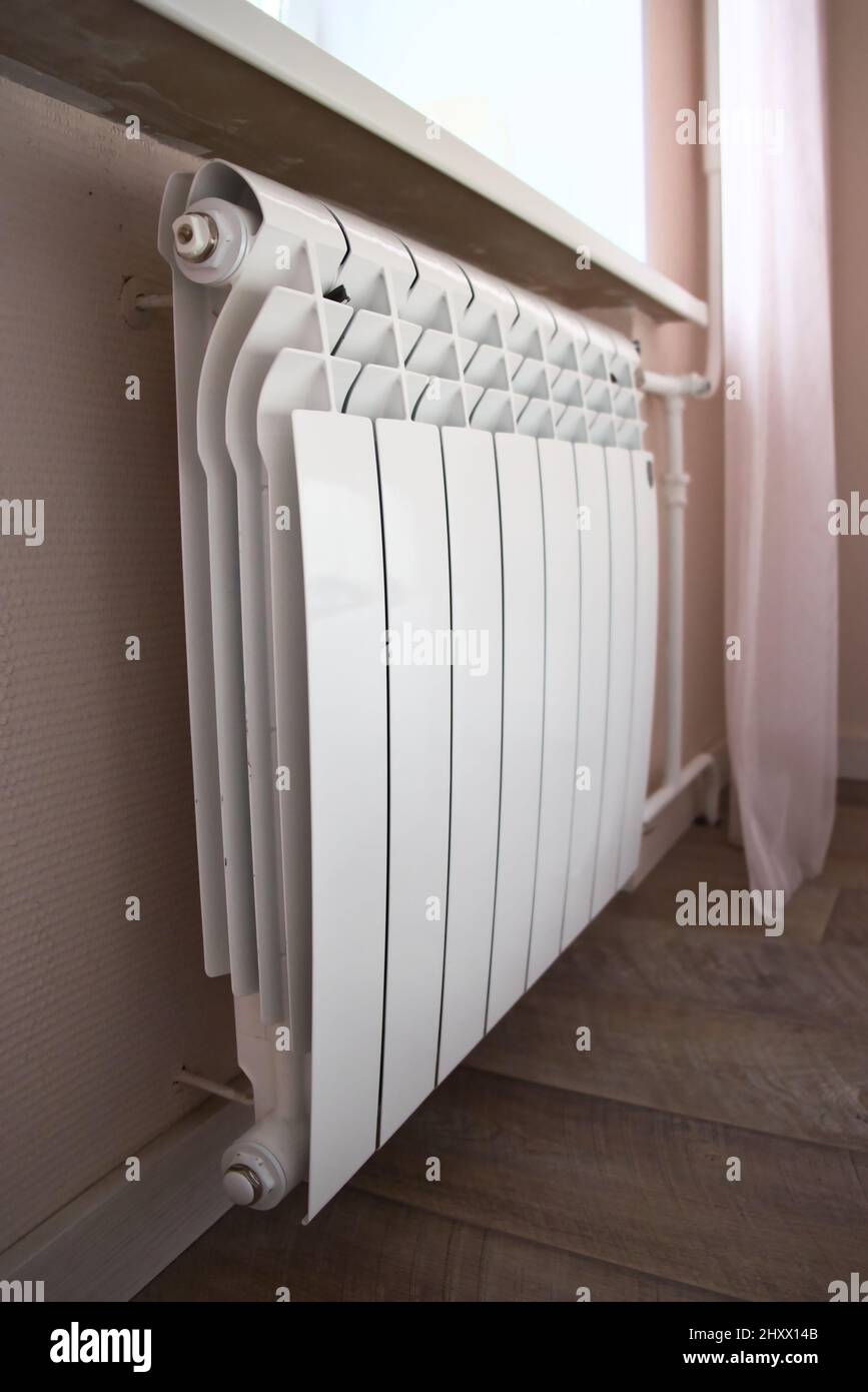 Modern home heating radiator under the window. Bimetal, aluminium radiator.  Heating system Stock Photo - Alamy