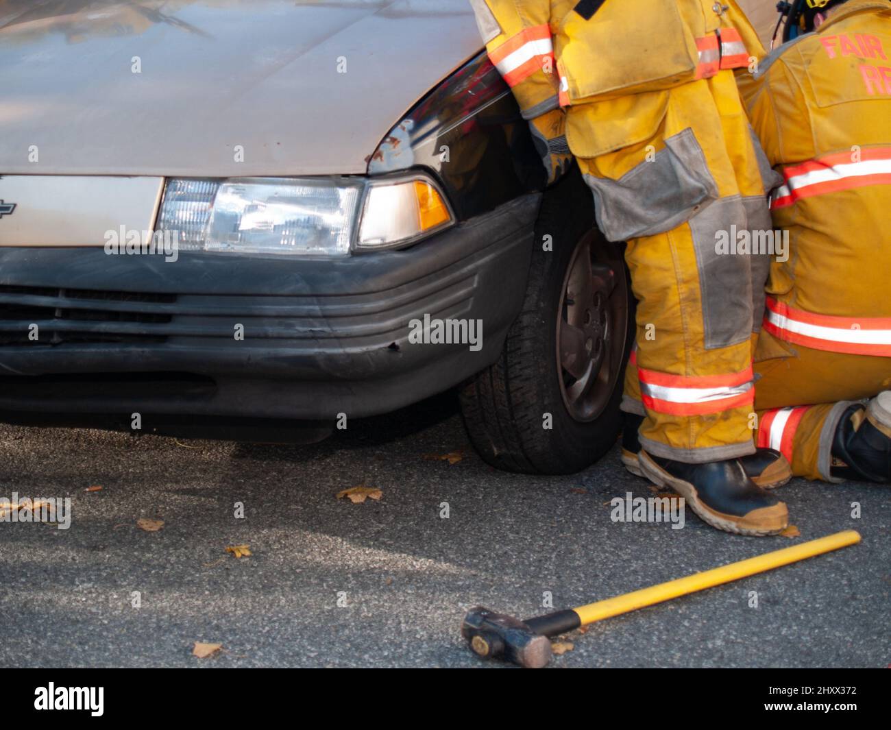 Rescue worker with wrecked car during drill Stock Photo
