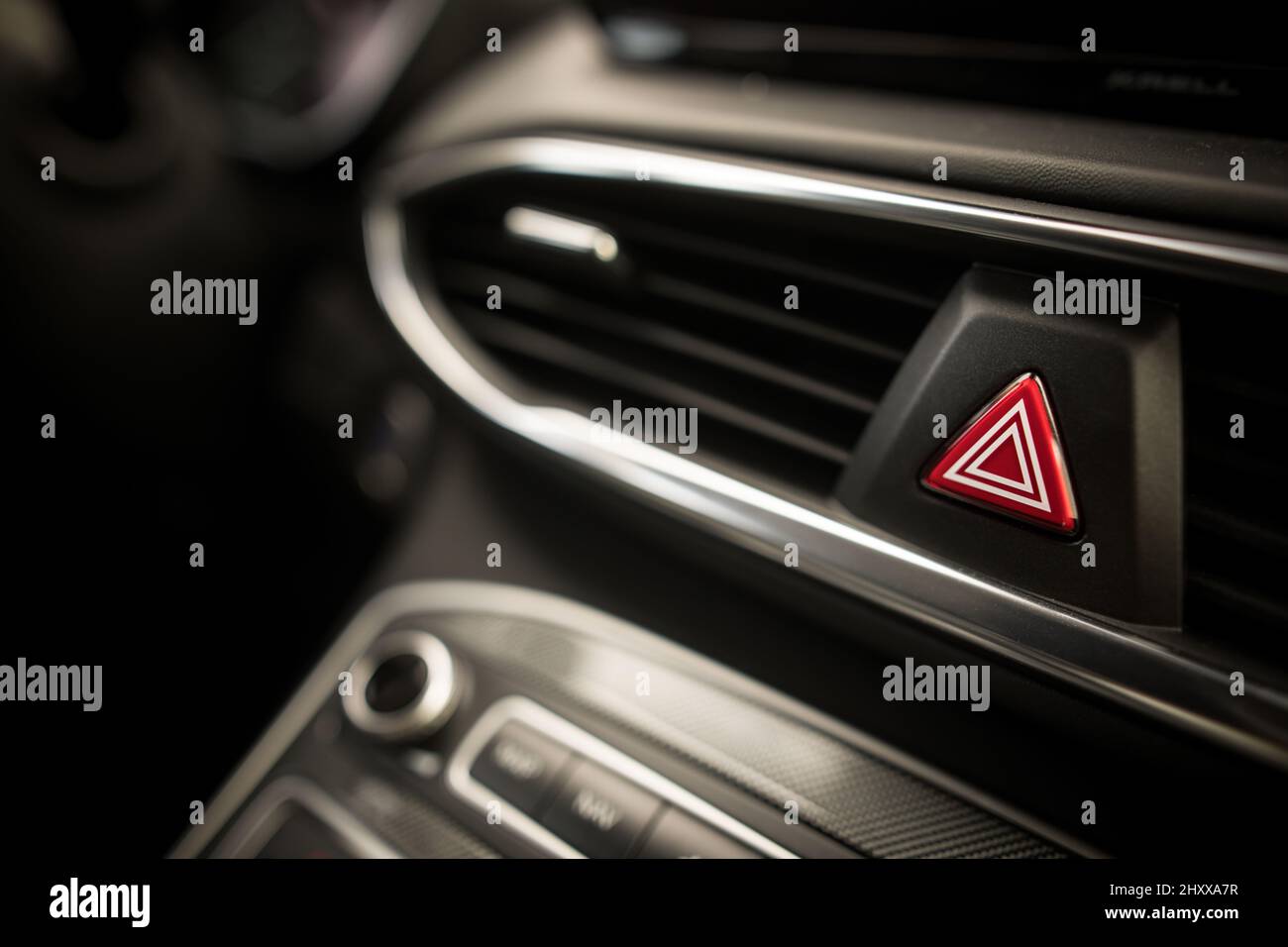 Emergency triangle button on black car dashboard Stock Photo