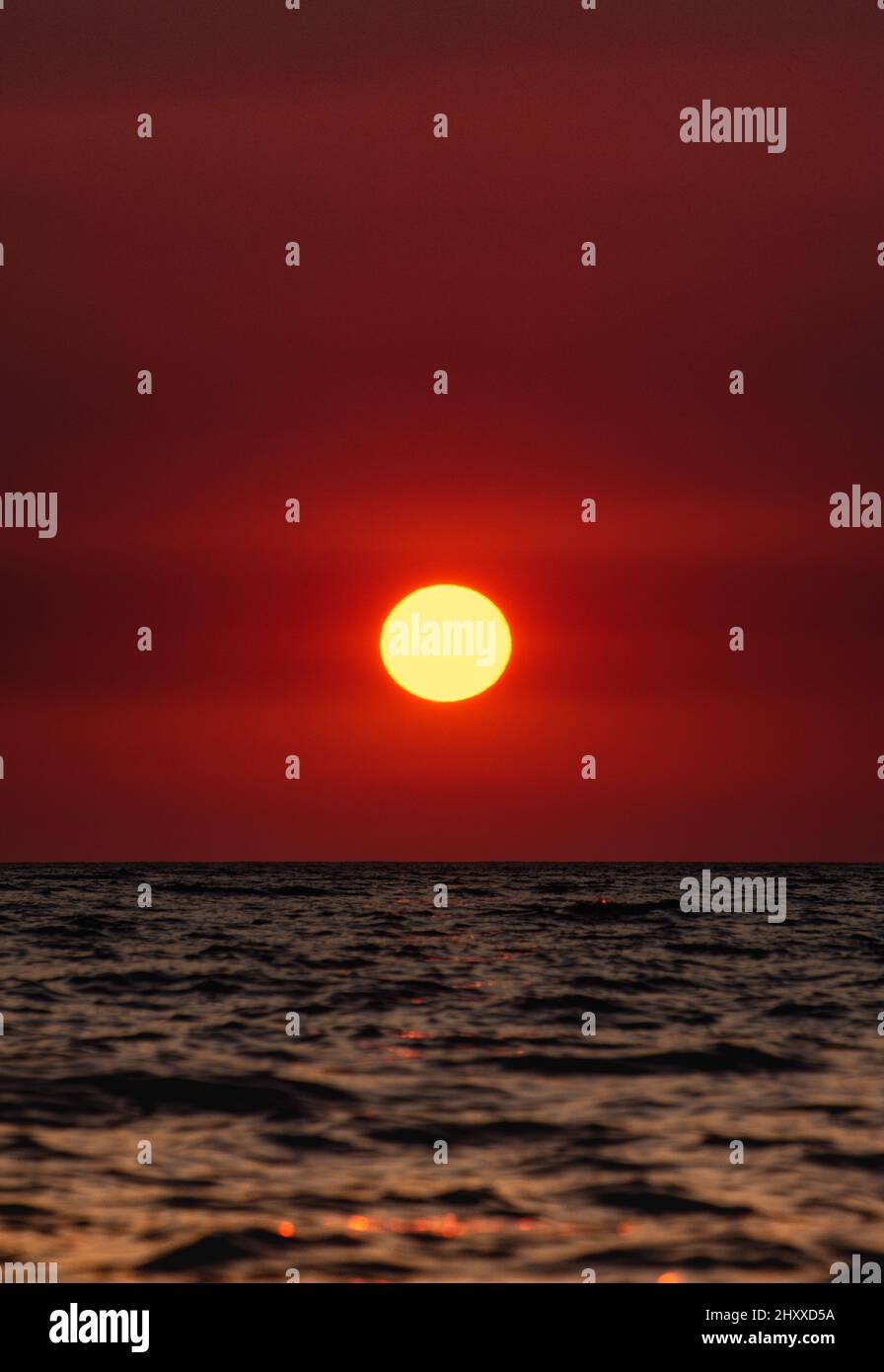 View of the sea waves under the magical red sunset Stock Photo - Alamy