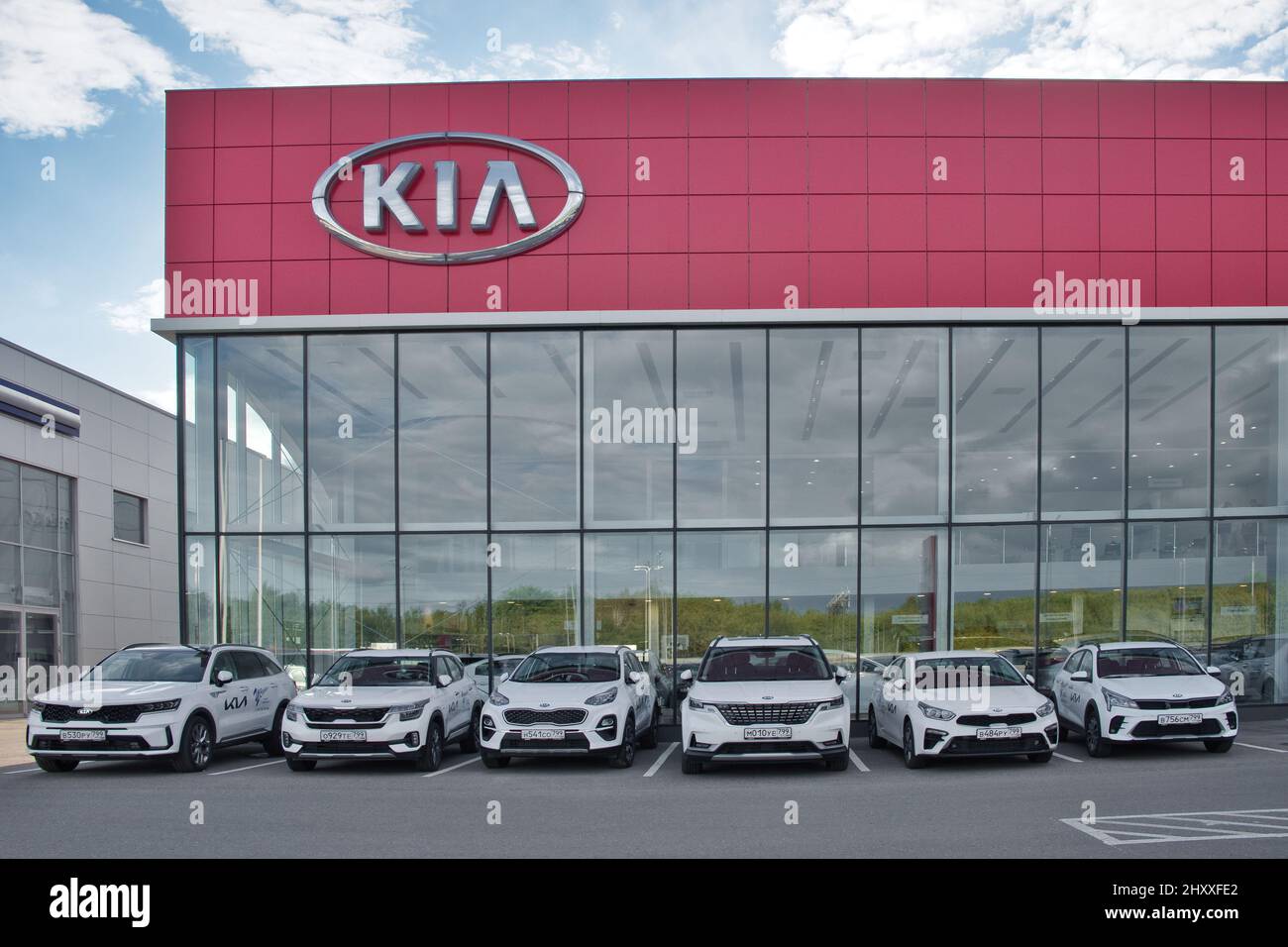 Moscow Region, Russia - September 2021: Building of KIA MOTORS car selling and service center. KIA logo on car showroom. New cars in a row outdoors. Stock Photo