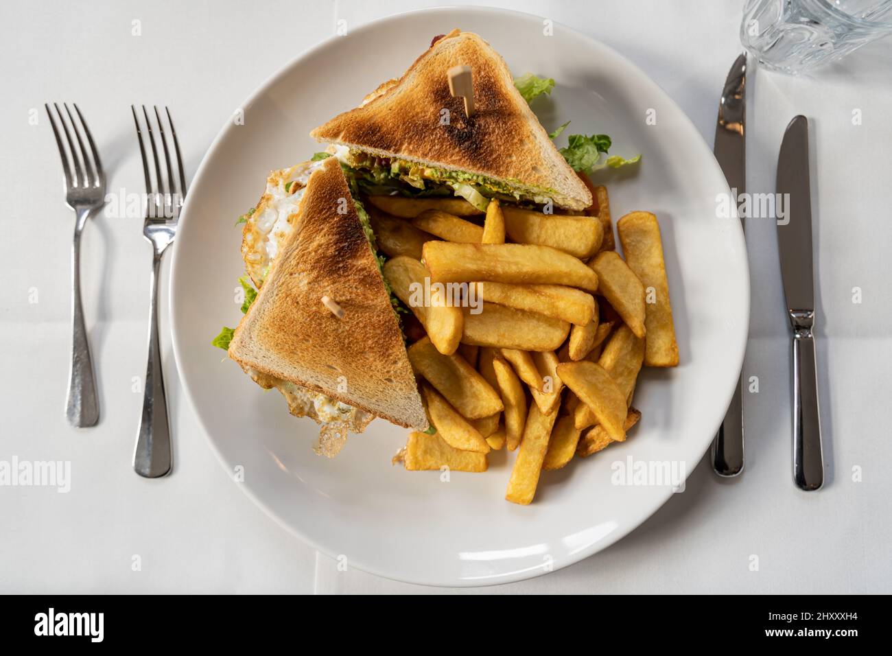 Top view of sandwiches and fries on a white plate with utensils Stock Photo  - Alamy