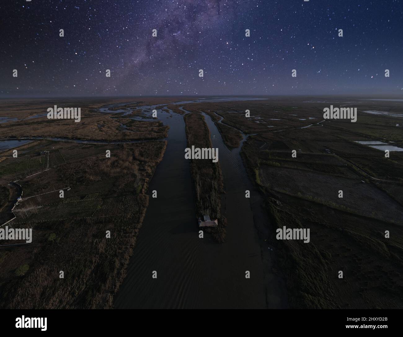 Aerial view of rivers near fields with a starry night sky in the ...