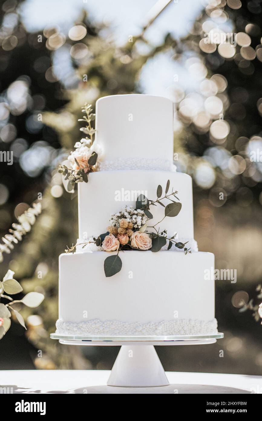 Beautiful white wedding cake with flowers Stock Photo - Alamy