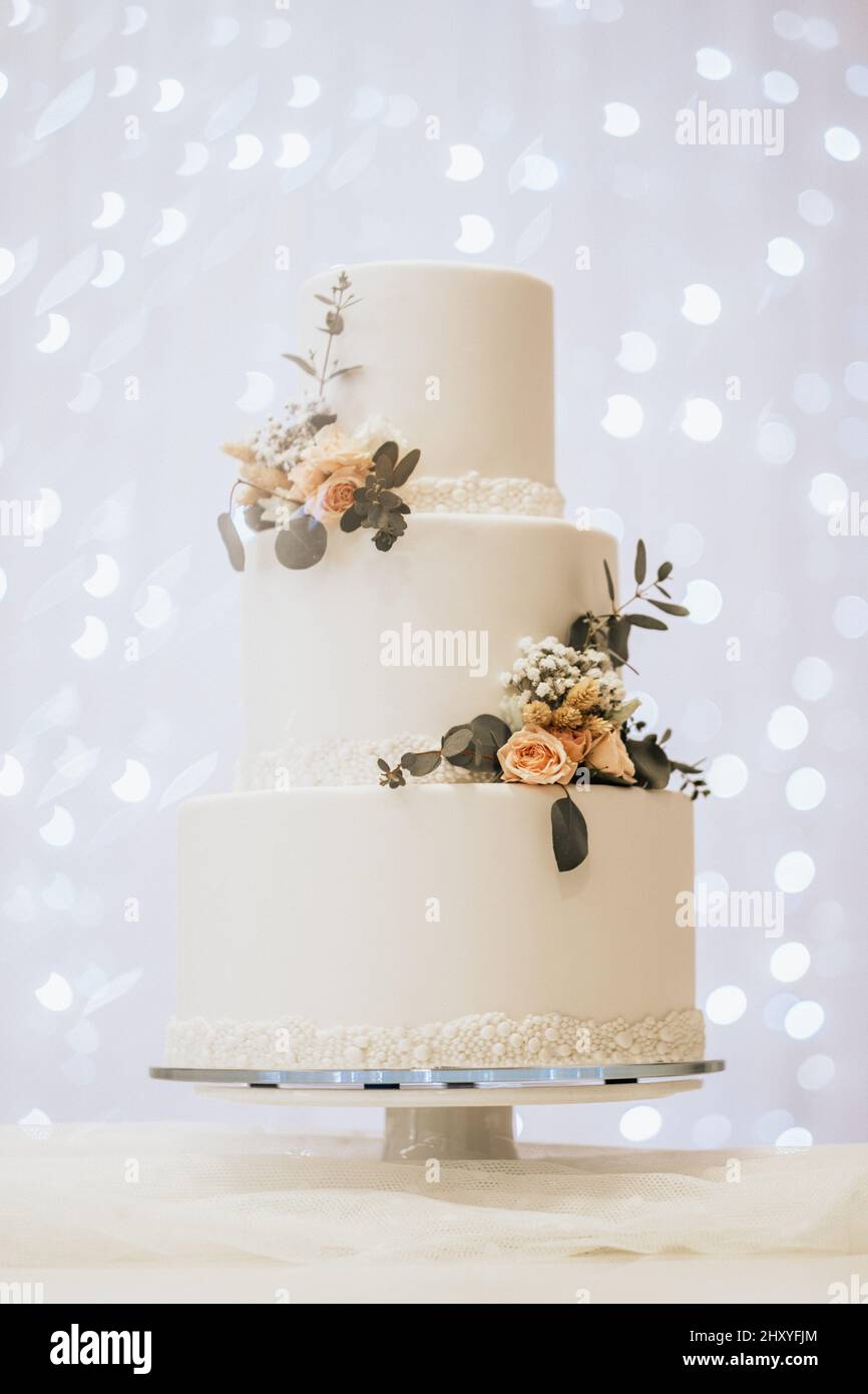 Beautiful white wedding cake with flowers Stock Photo - Alamy