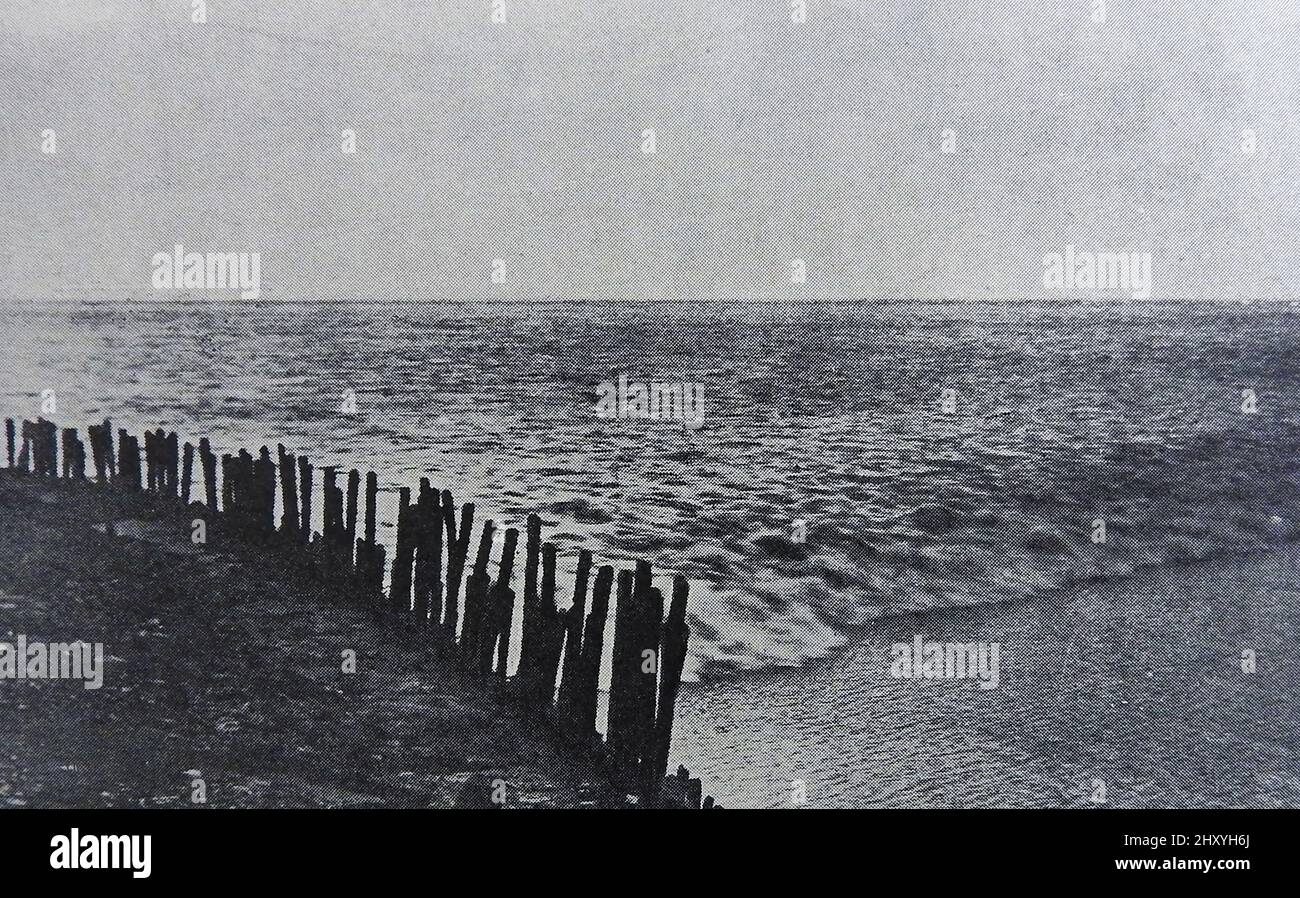 C1930s, the TIDAL BORE at Hangzhou Bay on the River Tseintang or Qiantang, China  (nicknamed the black or silver dragon) at full moon. It is considered the world's largest tidal bore. A tidal bore consists of a series of unusually large waves rushing  upstream against the  normal flow. Stock Photo