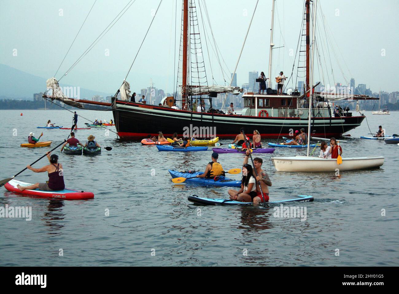 Sailing ship and people on paddling boards in English Bay Stock Photo