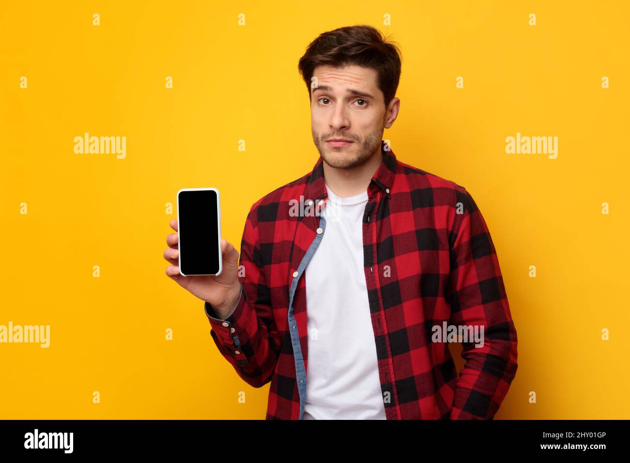 Sad guy holding showing empty smartphone screen Stock Photo