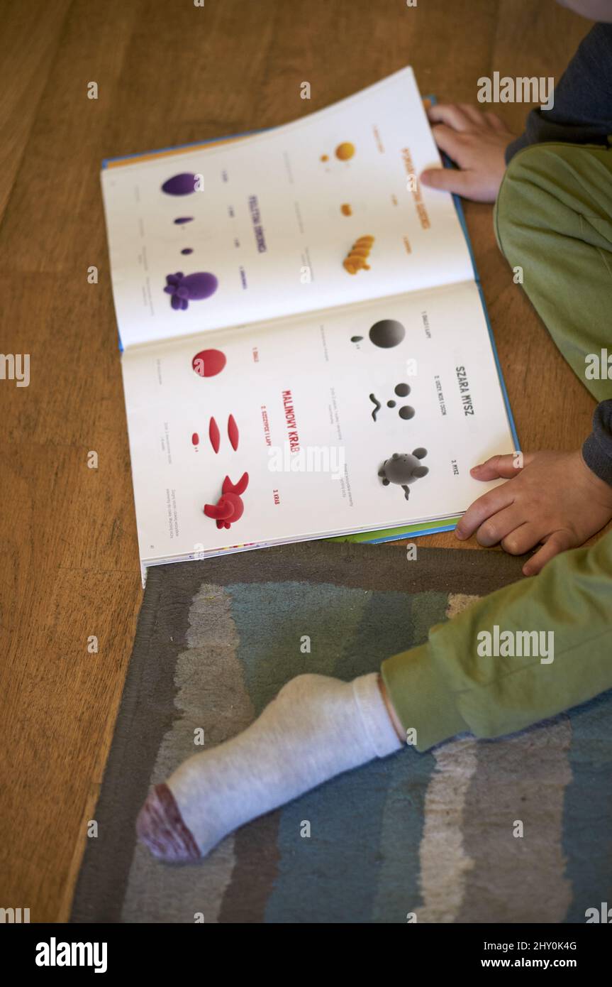 Child reading a book with clay model samples of the Hey Clay brand Stock Photo Alamy
