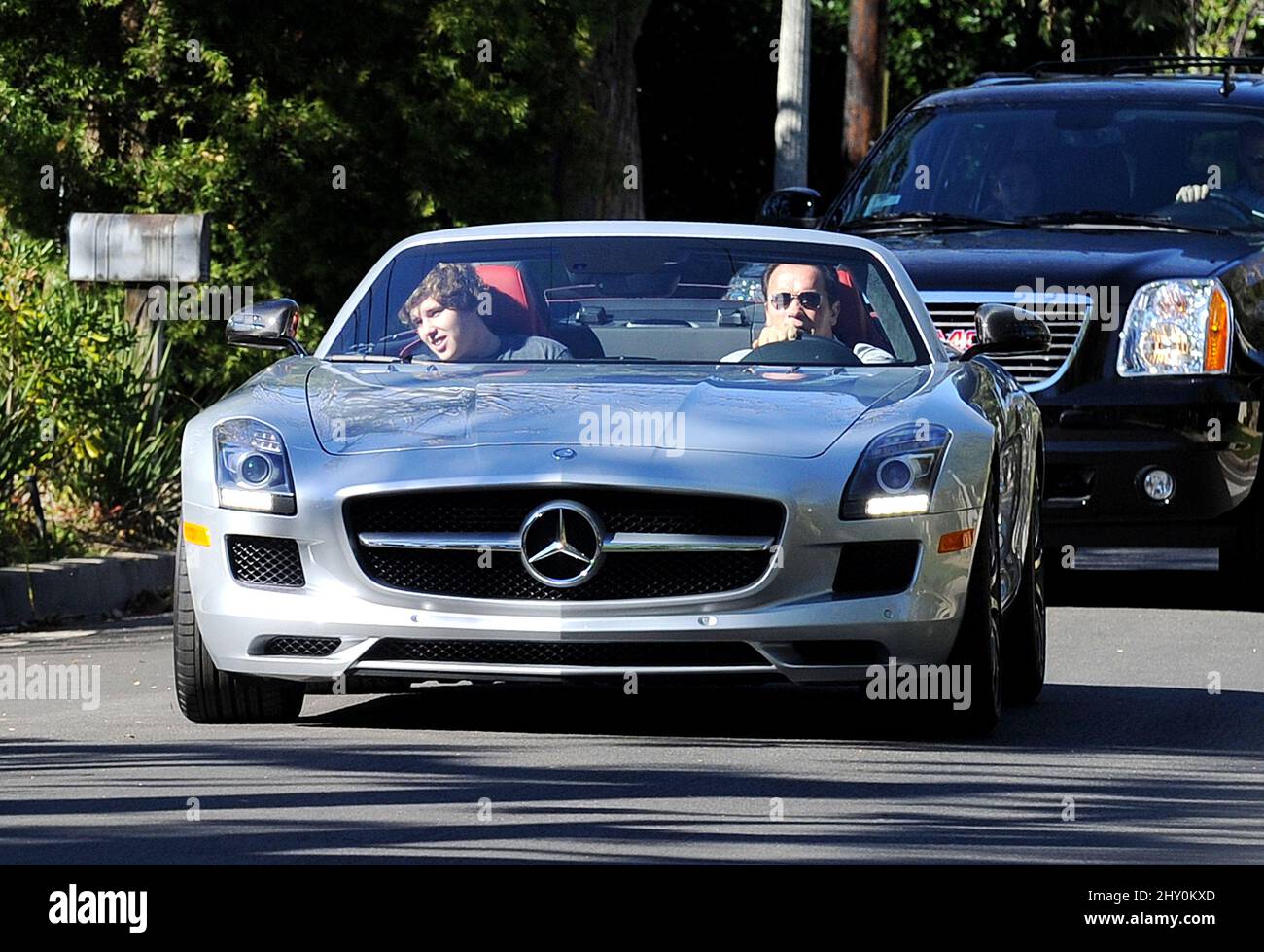 Arnold Schwarzenegger and his son go for a ride in his convertible
