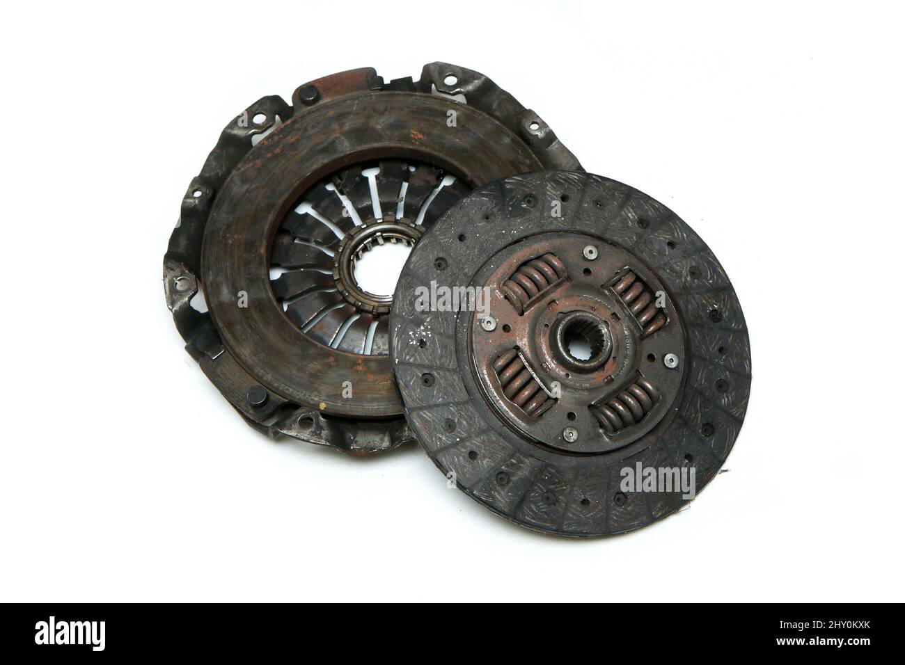 The old rusty used clutch from the car engine isolated in a white background. Has to be changed for new one. Stock Photo