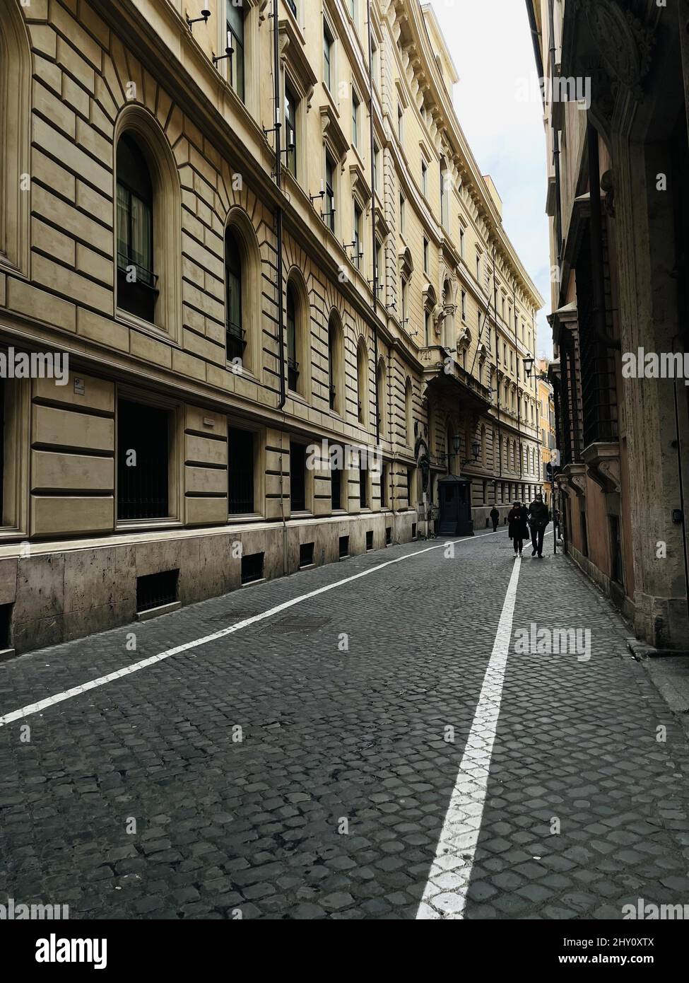 Vertical shot of people walking in a narrow street Stock Photo - Alamy