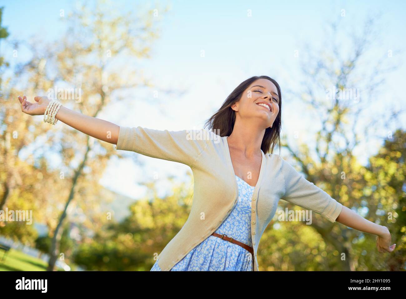 Nature loving. Shot of a carefree young woman enjoying a day at the park. Stock Photo