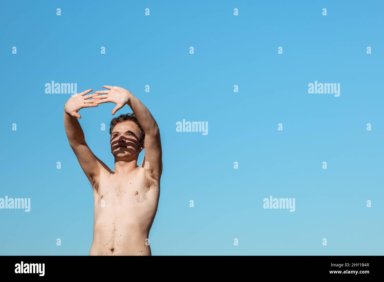 Young male freelancer typing on modern netbook while standing on street in city during online work Stock Photo