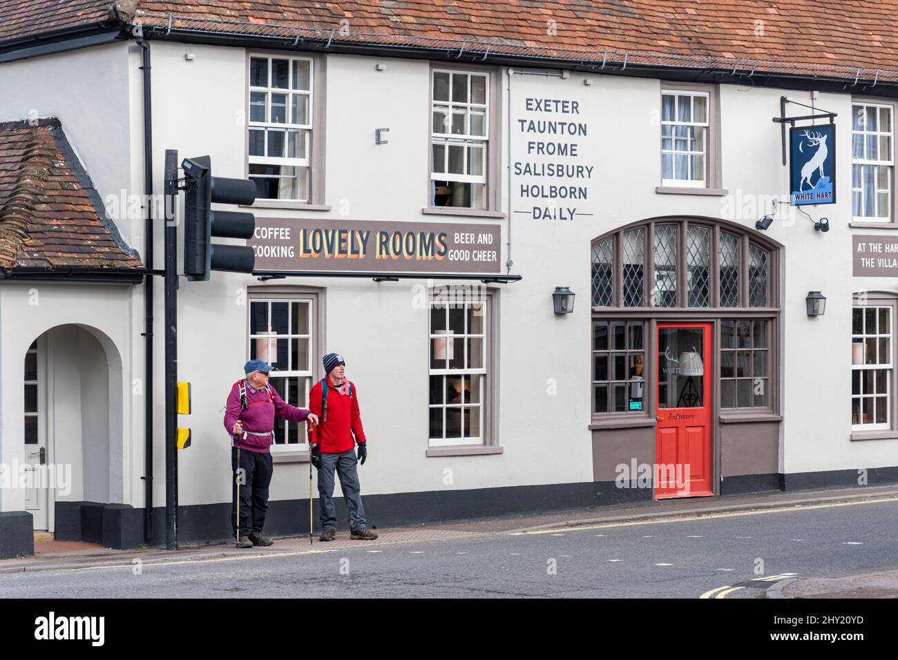 Overton village, Hampshire, England, UK, with two walkers on the High Street outside the White Hart pub Stock Photo