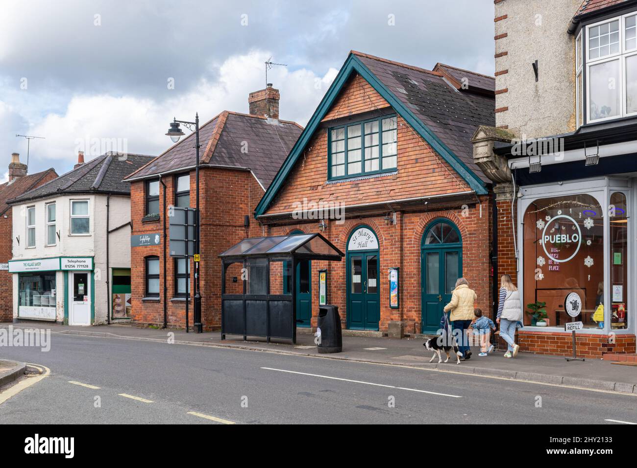 Overton village centre, Hampshire, England, UK, with a family walking
