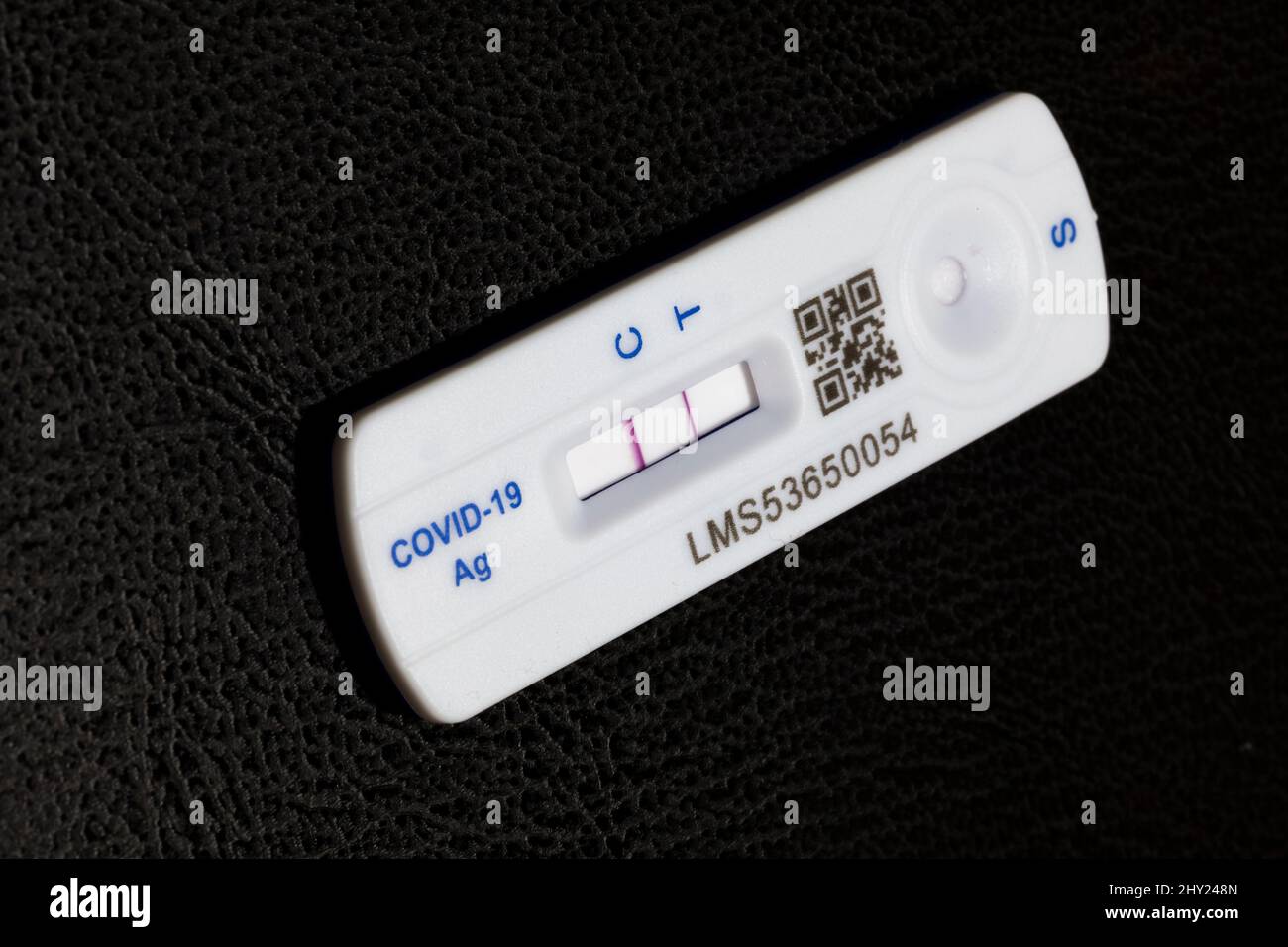 Positive Covid 19 lateral flow test / rapid lateral flow antigen coronavirus test on a black