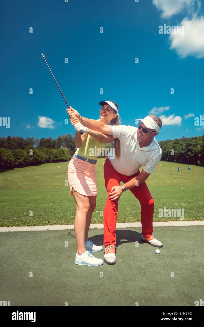 Golf pro teaching a woman student of the driving range Stock Photo