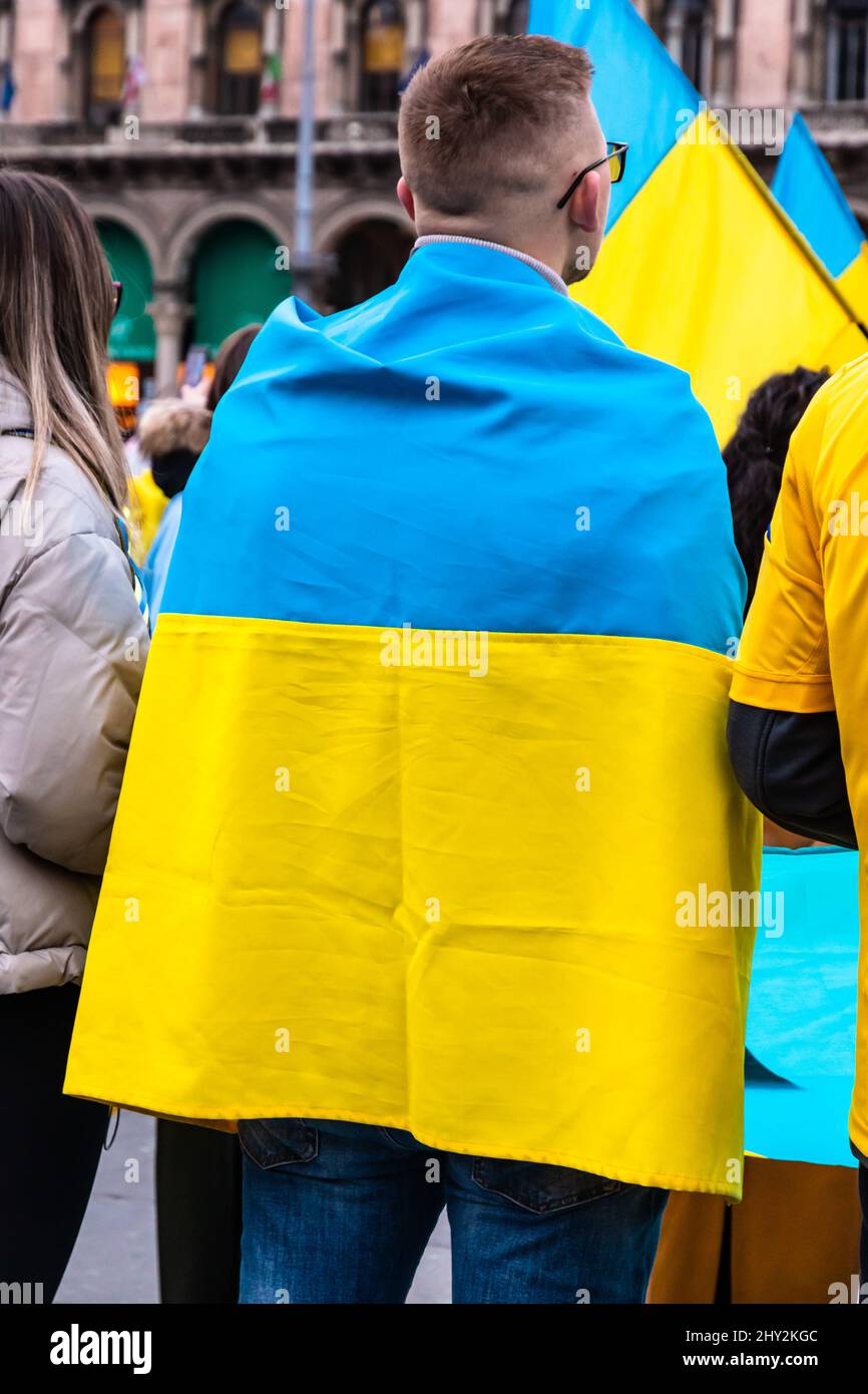 Young man wrapped in the Ukrainian flag in a protest against Russia invasion Stock Photo