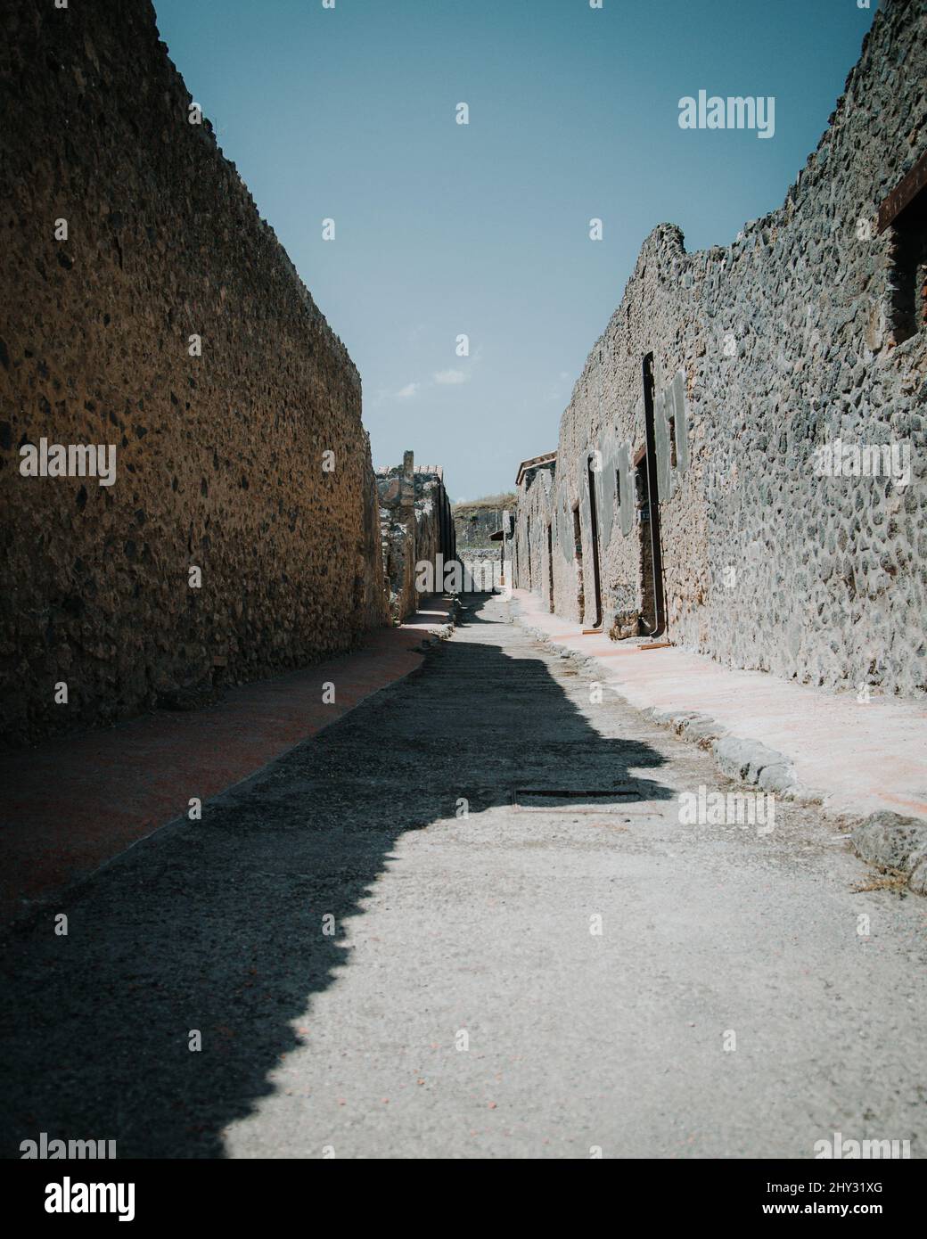 Vertical shot of a narrow walking path next to some old buildings Stock ...