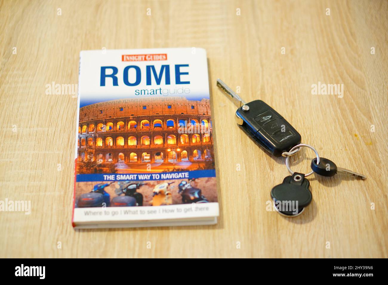 travel guide about Rome next to car keys on a table Stock Photo - Alamy