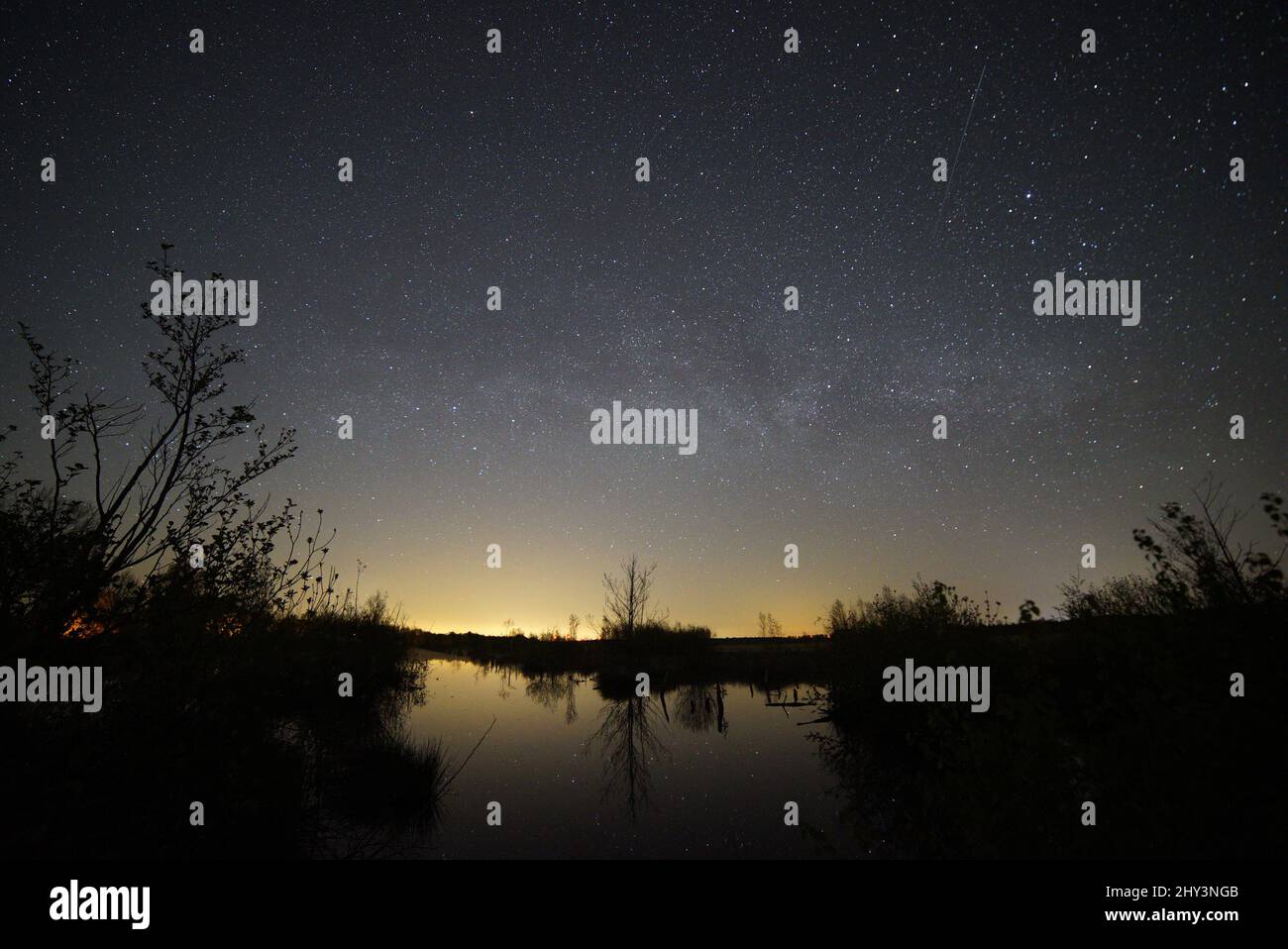 Scenic view of a lake reflecting the blue starry sky at night Stock ...