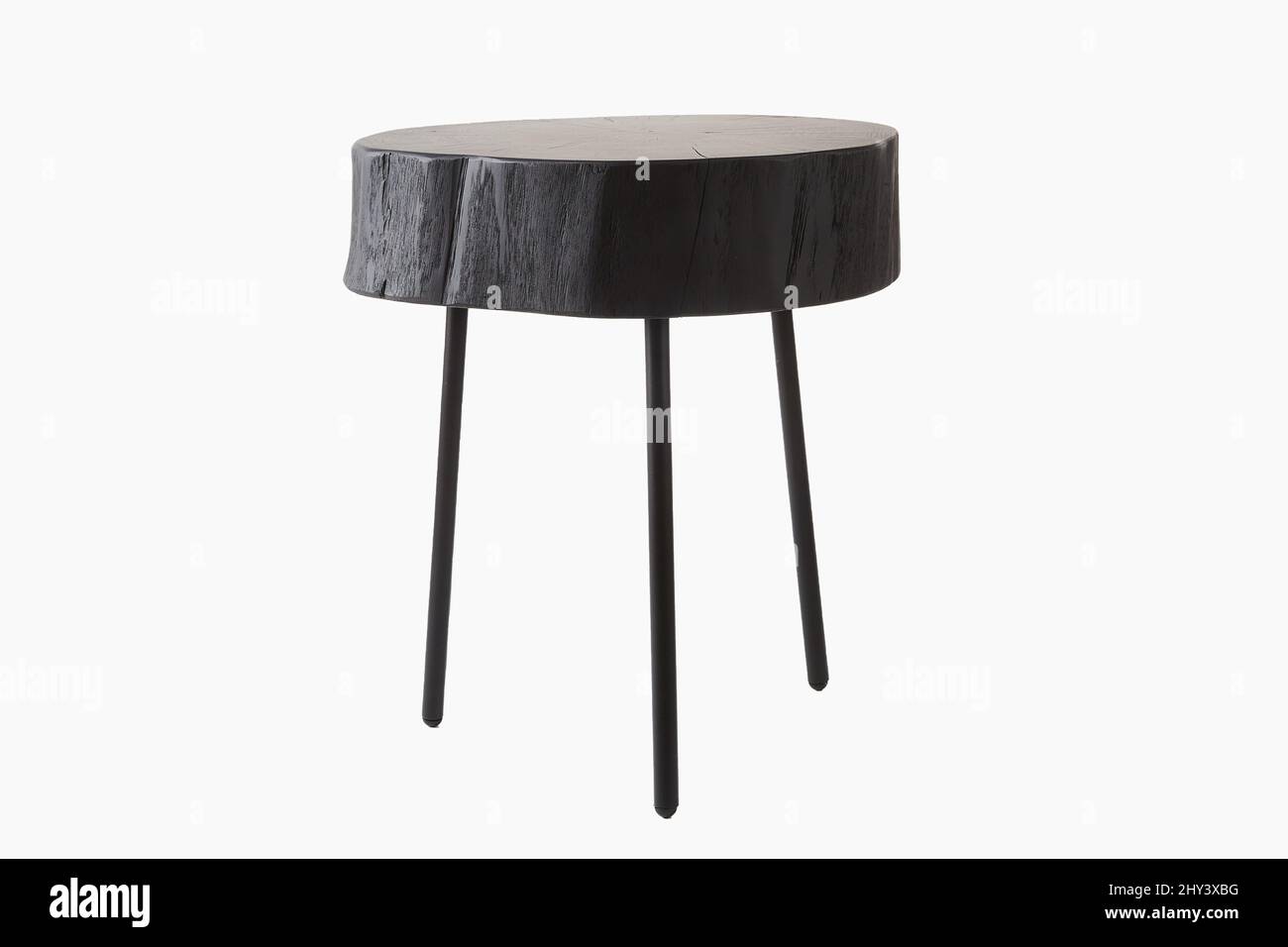 Shot of black three legged stool made of wood trunk and steel isolated on a white background Stock Photo